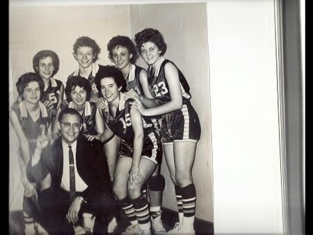 Informal black and white photograph of 1963 Porter High School State Champion Girls basketball team and coach Galen Johnson. Taken after the winning game.