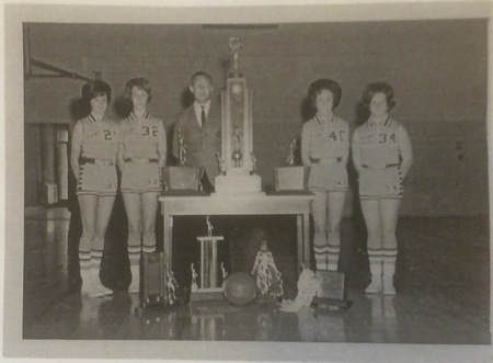 B&W formal photo of Coach Johnson and four of his 1967 Championship team with the State trophy.