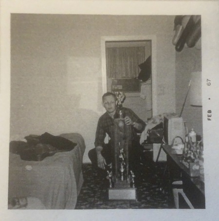 Polaroid, candid photo of Coach Johnson with the 1967 Tennessee State Champion trophy.